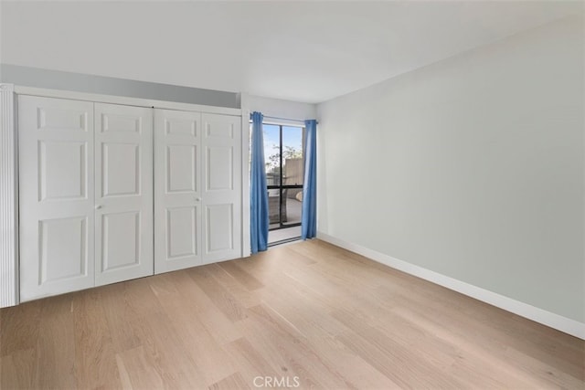 unfurnished bedroom featuring light hardwood / wood-style floors and a closet