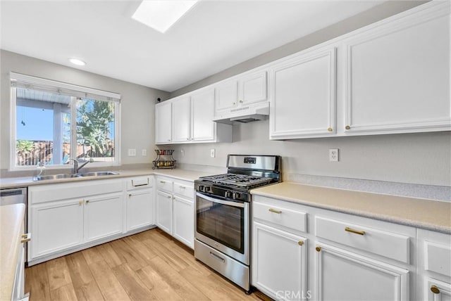 kitchen featuring white cabinetry, light wood-type flooring, sink, and appliances with stainless steel finishes