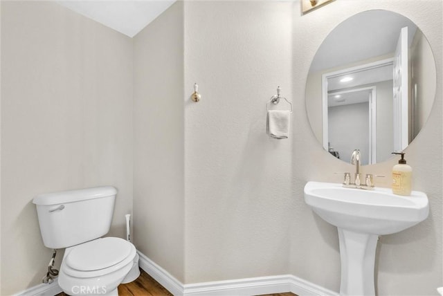 bathroom featuring wood-type flooring and toilet