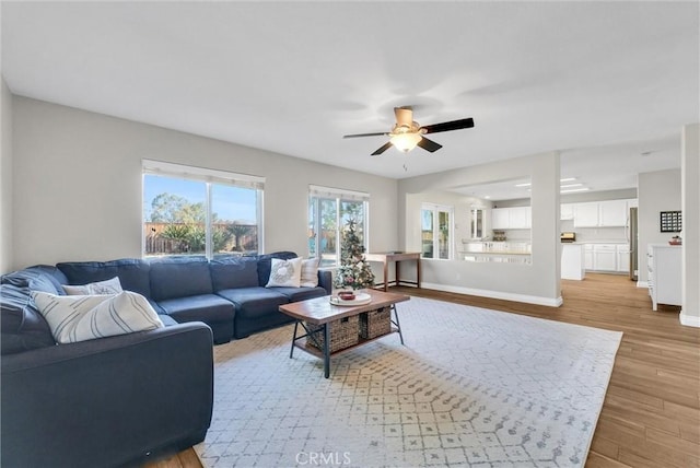 living room with ceiling fan and light hardwood / wood-style flooring