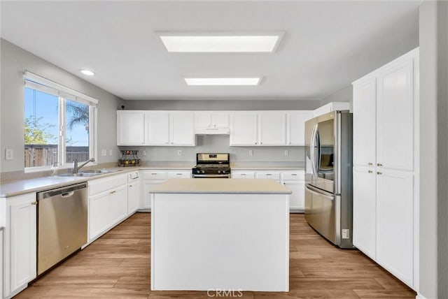 kitchen featuring sink, a center island, light hardwood / wood-style flooring, white cabinets, and appliances with stainless steel finishes