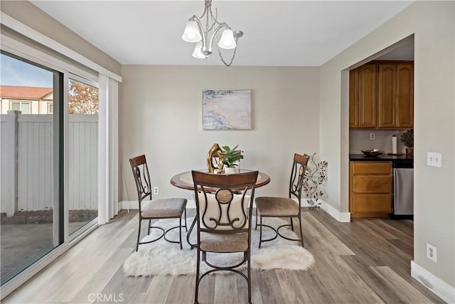 dining space featuring a notable chandelier and light hardwood / wood-style floors