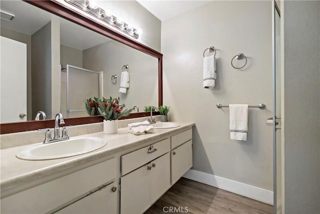 bathroom featuring wood-type flooring, vanity, and a shower with shower door