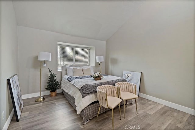 bedroom featuring vaulted ceiling and light wood-type flooring