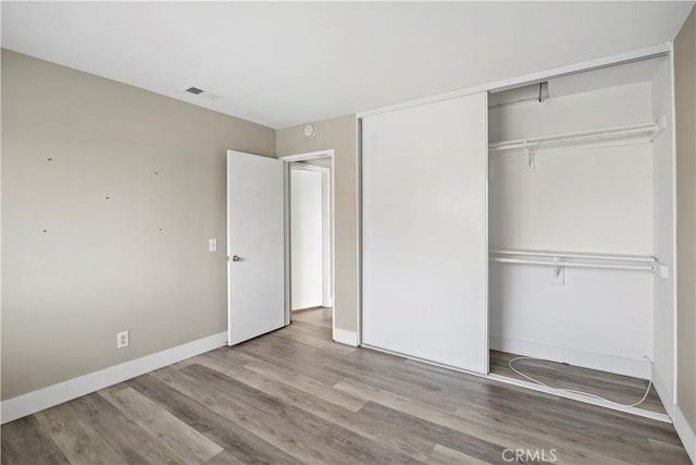 unfurnished bedroom with light hardwood / wood-style floors and a closet