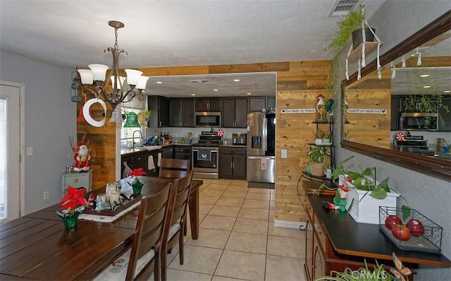 dining room with light tile patterned floors, an inviting chandelier, a wealth of natural light, and sink