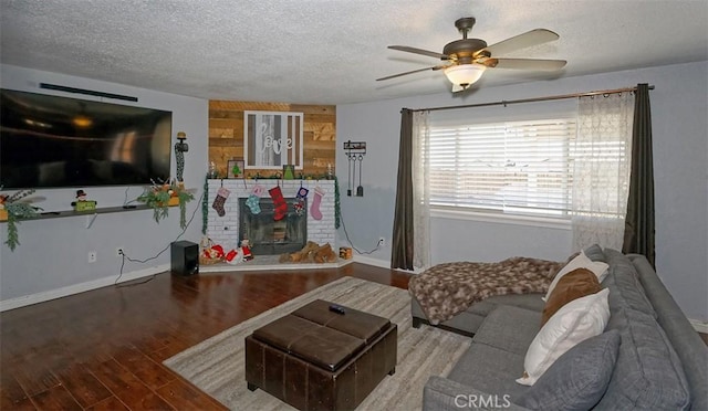 living room with hardwood / wood-style floors, a textured ceiling, and ceiling fan