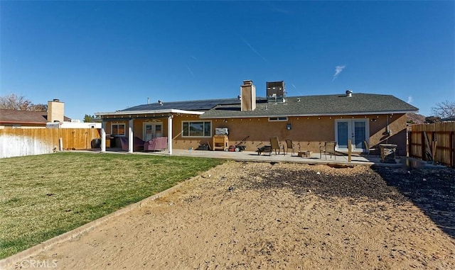 rear view of house with a patio area, a yard, and french doors