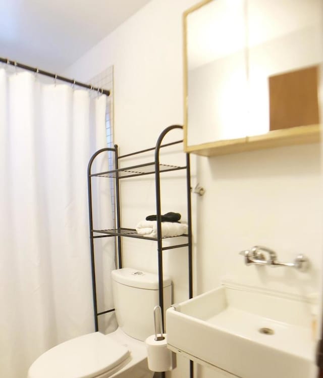 bathroom with toilet, vanity, and walk in shower