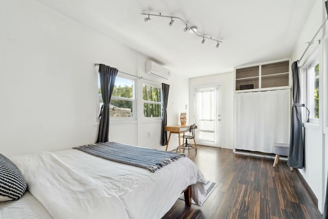 bedroom with multiple windows, dark hardwood / wood-style flooring, a closet, and a wall mounted AC