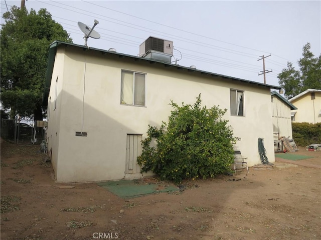 rear view of property with central AC