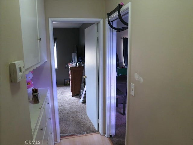 hallway with light colored carpet