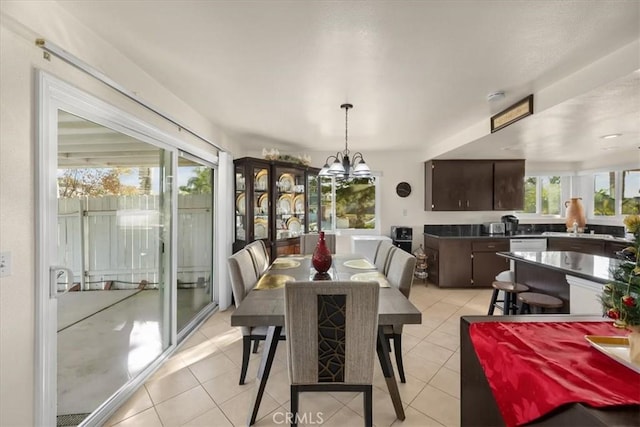 dining space with light tile patterned floors and an inviting chandelier