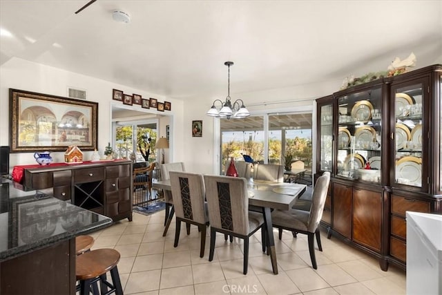 dining area featuring a notable chandelier and light tile patterned floors