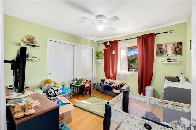 bedroom with a closet, hardwood / wood-style flooring, and ceiling fan