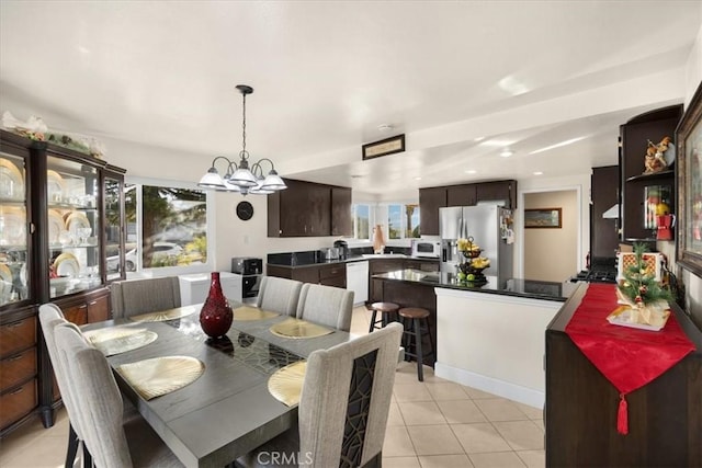 tiled dining area featuring a chandelier and plenty of natural light