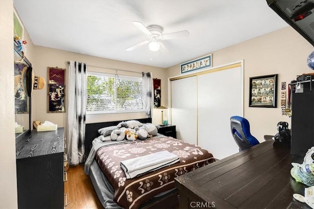 bedroom with hardwood / wood-style floors, ceiling fan, and a closet