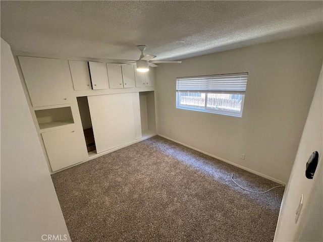 unfurnished bedroom featuring a textured ceiling, carpet floors, and ceiling fan