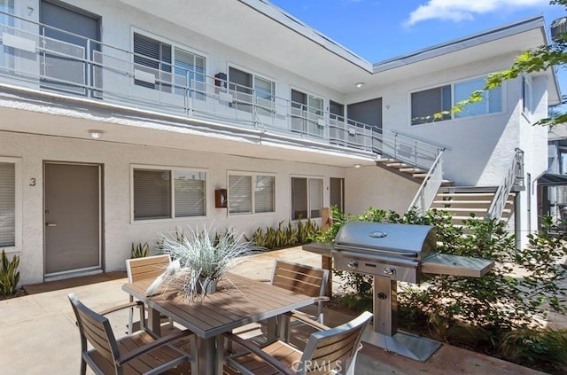 view of patio featuring a grill and a balcony