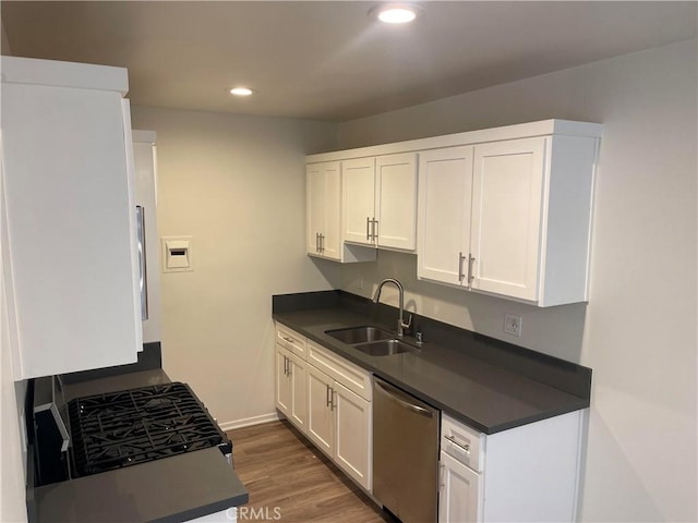 kitchen with dark wood-type flooring, sink, white cabinets, and stainless steel appliances