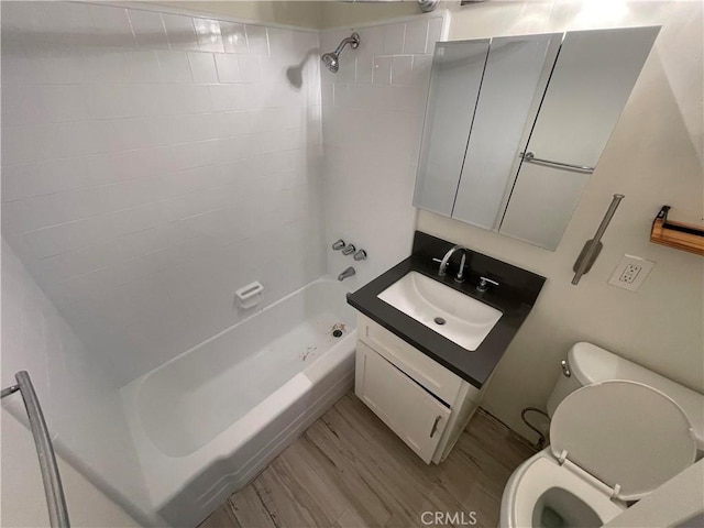 full bathroom with toilet, hardwood / wood-style floors, vanity, and tiled shower / bath