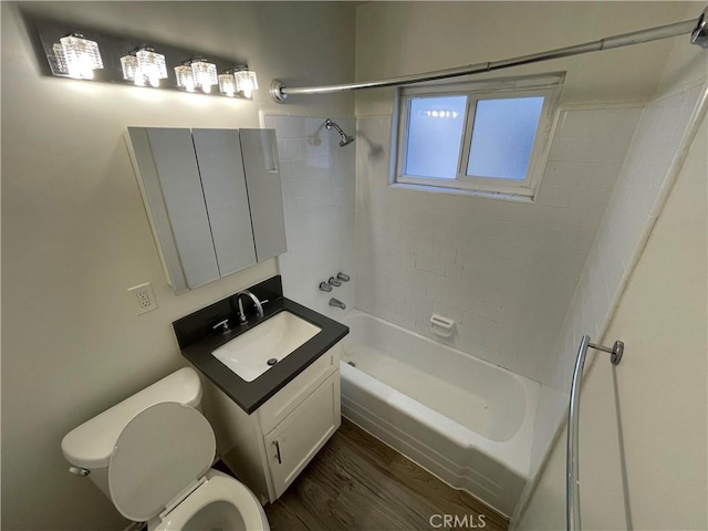 full bathroom with hardwood / wood-style flooring, tiled shower / bath combo, toilet, and vanity