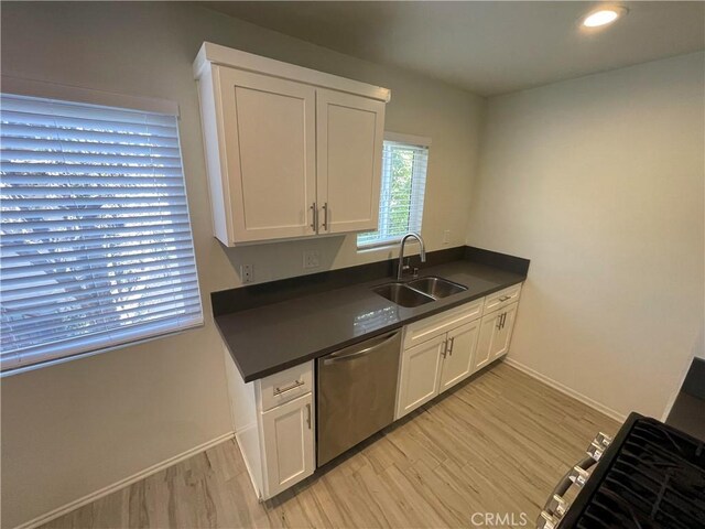 kitchen featuring stainless steel dishwasher, light hardwood / wood-style floors, white cabinetry, and sink