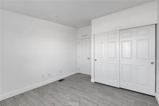 unfurnished bedroom featuring a closet and light hardwood / wood-style flooring