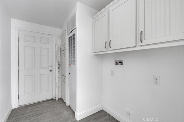 laundry area with cabinets, hookup for a washing machine, and hardwood / wood-style floors