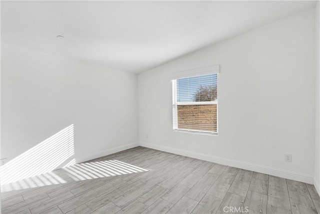 empty room featuring light hardwood / wood-style floors and lofted ceiling