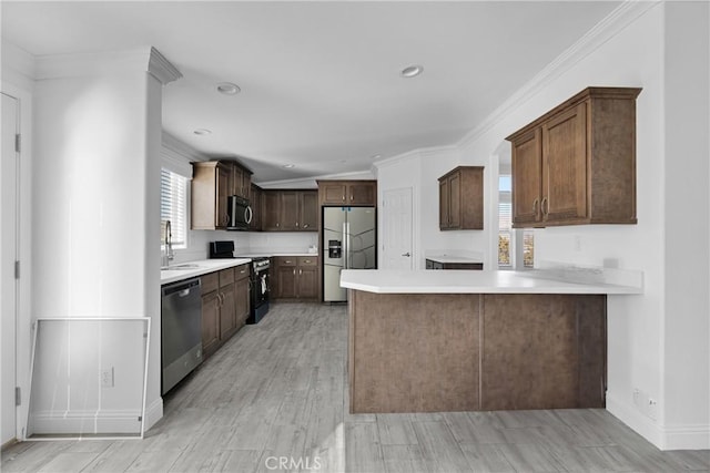 kitchen with kitchen peninsula, appliances with stainless steel finishes, light wood-type flooring, and plenty of natural light