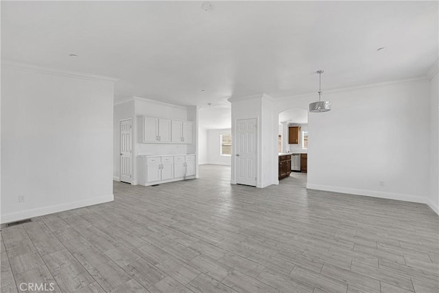 unfurnished living room featuring light wood-type flooring and crown molding