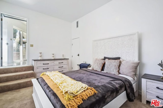 bedroom with light carpet and lofted ceiling