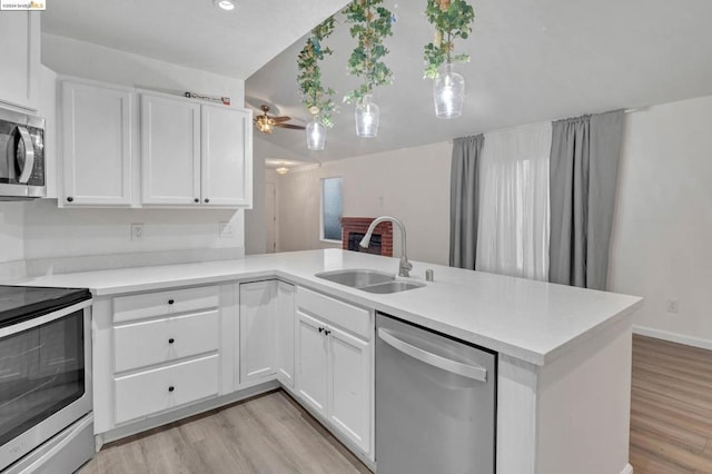 kitchen with ceiling fan, stainless steel appliances, kitchen peninsula, and sink