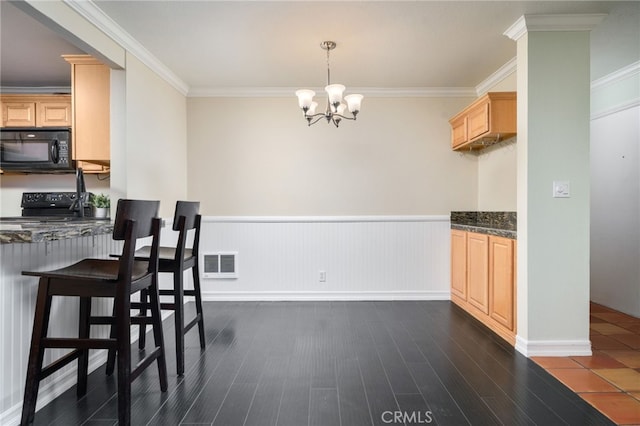 kitchen featuring light brown cabinetry, black appliances, and crown molding