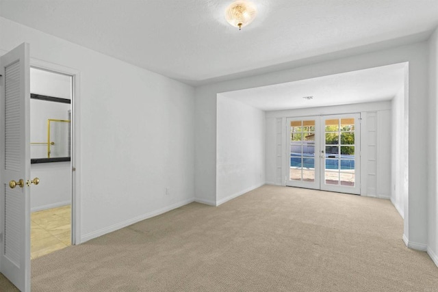 empty room with french doors and light colored carpet