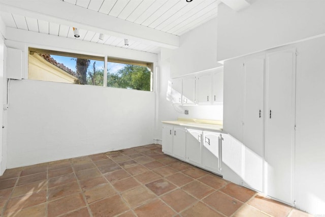 laundry area featuring tile patterned floors and wood ceiling