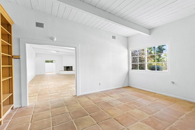 tiled empty room featuring vaulted ceiling with beams and wooden ceiling