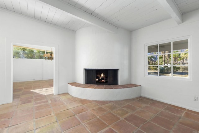 unfurnished living room with beamed ceiling, a wealth of natural light, a fireplace, and wood ceiling