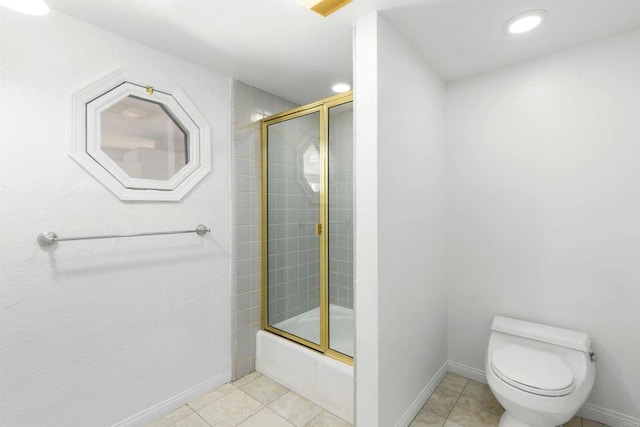 bathroom featuring combined bath / shower with glass door, tile patterned flooring, and toilet