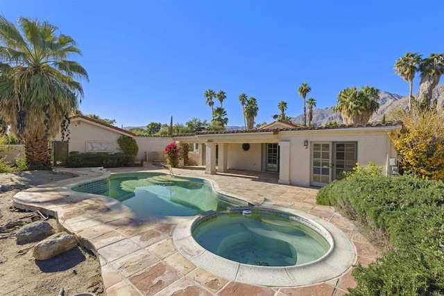 view of swimming pool with a mountain view, an in ground hot tub, and a patio