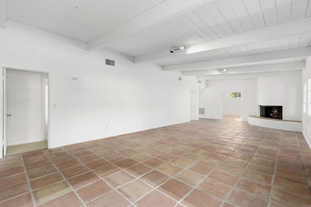 unfurnished living room with beam ceiling