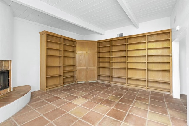 interior space with tile patterned floors, built in shelves, wooden ceiling, and a fireplace