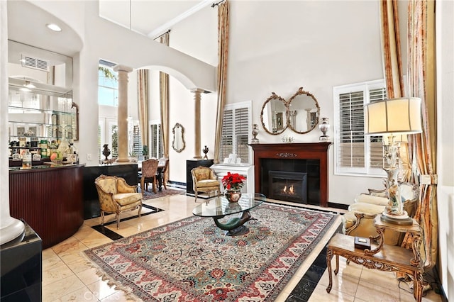 sitting room with a high ceiling and ornate columns