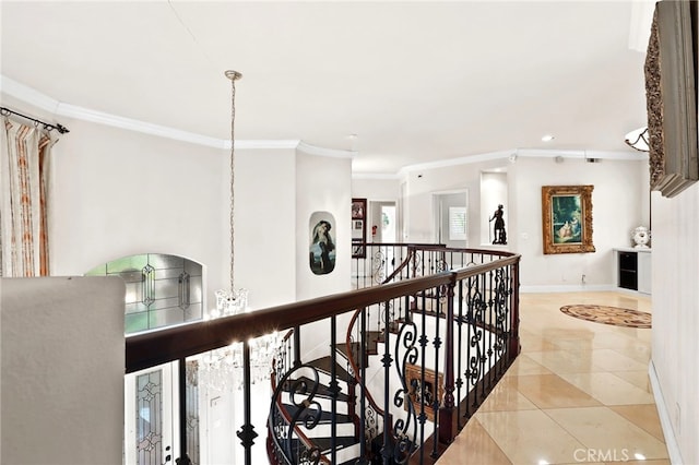 hall with light tile patterned floors, a notable chandelier, and ornamental molding