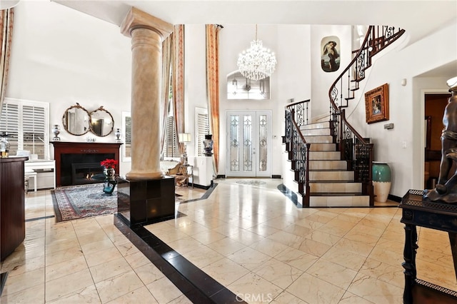 entrance foyer featuring a notable chandelier, a high ceiling, and ornate columns