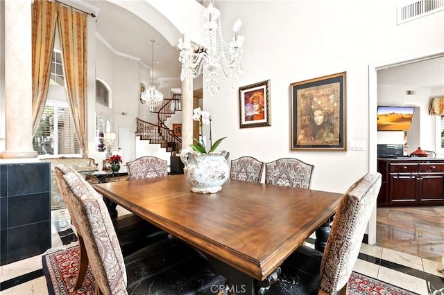 dining space with a chandelier, decorative columns, and a high ceiling