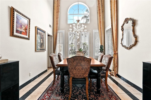 dining space with a notable chandelier and a high ceiling