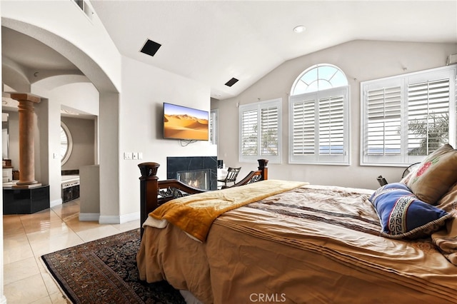 tiled bedroom with vaulted ceiling and ornate columns