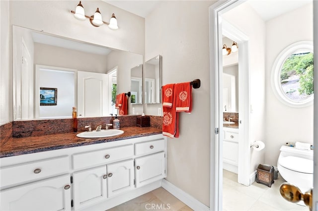 bathroom featuring vanity, tile patterned flooring, and toilet